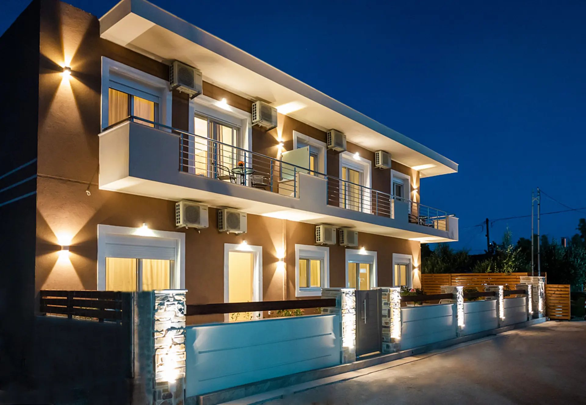 Το κτίριο του Orea Homes στην Αμμουδιά το βράδυ, με φωτισμένα μπαλκόνια